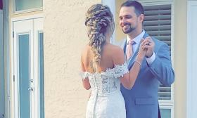 A bride showcasing an intricate braid shares a moment with the groom