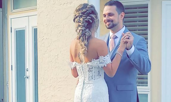 A bride showcasing an intricate braid shares a moment with the groom