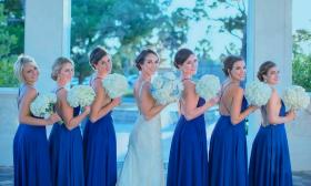 Bride and bridesmaids posing outside and wearing makeup by Christine Burns