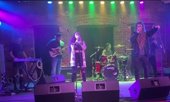 Reggae / dub band Root Sea on stage, five men and one woman.