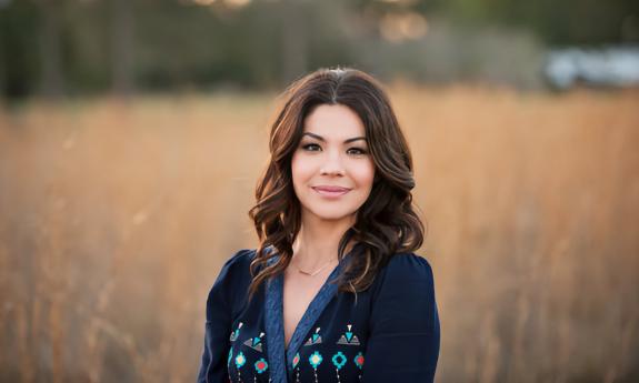 A picture of makeup artist Sarina Durden posing in a field