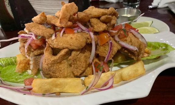 A plate of jalea fish with yucca and onions 