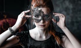 A masquerade ball guest showcasing her mask