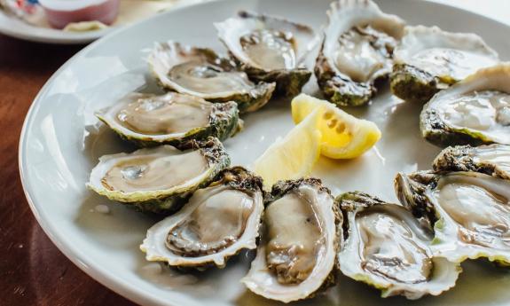 An oyster dish with lemons in the middle 