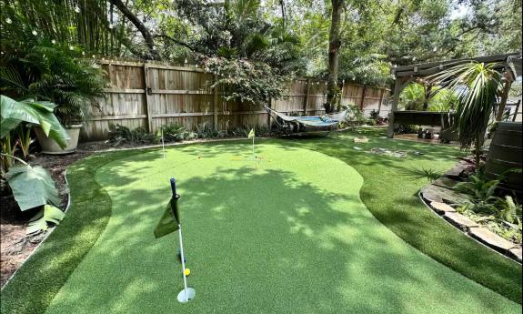 The putting green at Casa Paraiso sits under the shade of mature trees in a large back yard