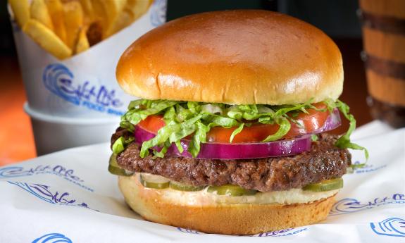 A juicy beach burger from Salt Life Food Shack, with fries in the background