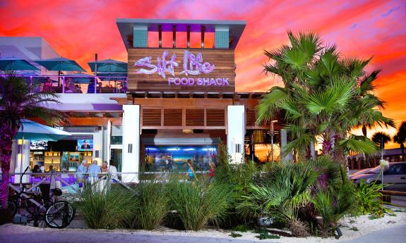 Salt Life Food Shack against a bright orange and pink sunset