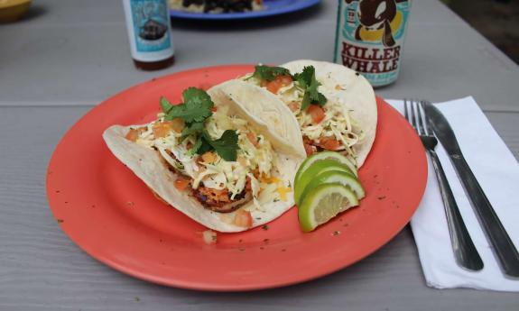 Plated shrimp tacos with limes on the side