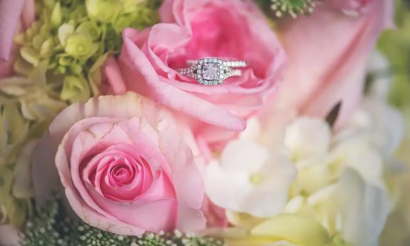 Glittering wedding ring nestled in a pink rose