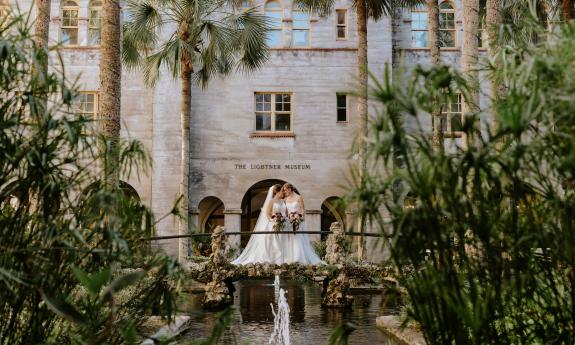 Brides posing in front of the Lightner Museum on their wedding day