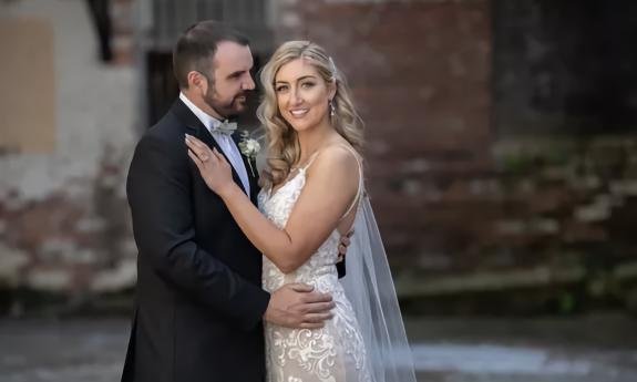 Bride and groom posing in front of an old brick building