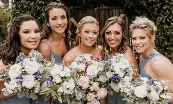 Bridal party posing with floral arrangements