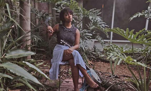 Musician Noan Partly sitting placidly in a garden