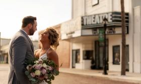 Couple standing in front of Clay Theatre on their wedding day
