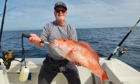 Man displays his catch on Todd's Rods Fishing Charters
