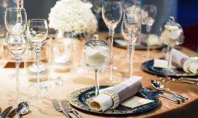 Event table setting featuring stemmed glasses and white flowers