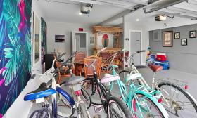 The game room, in the former garage, has bikes, beach gear, a tiki bar, and a game table
