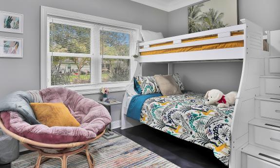 The bunk room, with storage, a chair for curling up, and a double under a twin bed