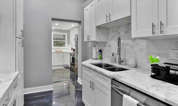 The butler's pantry with storage, a sink and large dishwasher