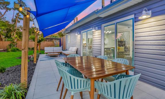 The deck off the great room has dining and sitting areas, a grill, and a cover