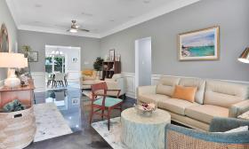 The living room has two conversation areas and a grey, aqua, and cream decor
