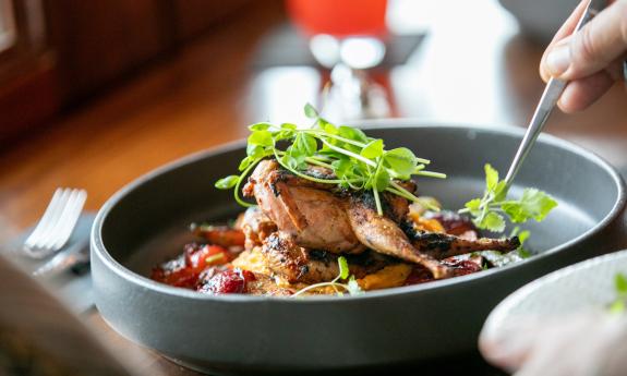 A food dish being prepared and garnished from Castillo Craft Bar + Kitchen