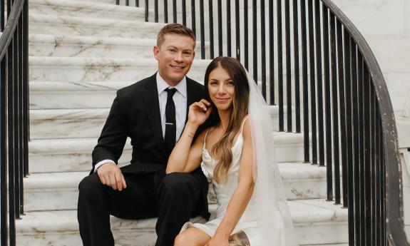 Bride and groom posing on a marble staircase