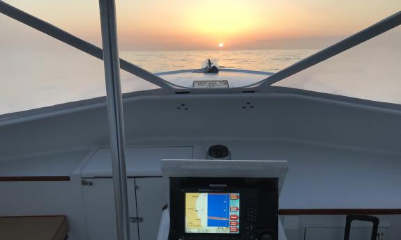 The view of the sun setting over the water from the boat