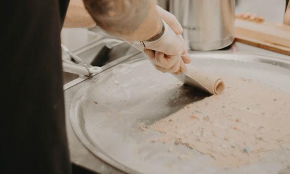 An employee rolling ice cream on a chilled surface