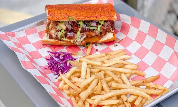 A plated birria torta with a side of fries