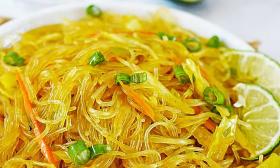 A bowl of pancit with limes on the side