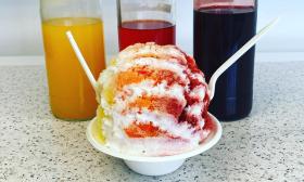 A shaved ice cup with three flavors and toppings