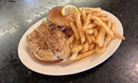 A plated sandwich and fries on the side