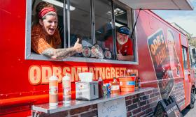 Jessie Kresa, on the left, gives a thumbs up while serving up meals out of the food truck