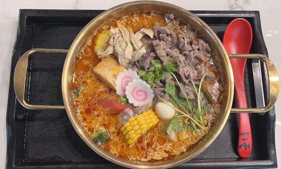 A bowl of hot pot soup served at Oola Mala