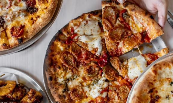 Various pizza slices being served at the eatery