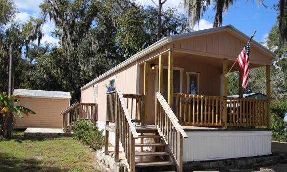 The one-bedroom Park Model home has a porch and full kitchen