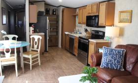 The living, dining area, and kitchen of the Park Model that's available for rent at Hideaway Trail
