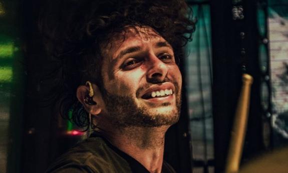 Orlando Muñiz with a drum stick onstage