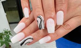 white Coffin-shaped nails with two accent designs with black and silver swirls