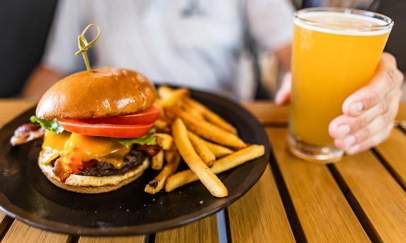 A burger and fries meal paired with a glass of beer