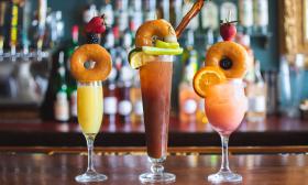 Specialty brunch drinks topped with donuts and additional garnishes