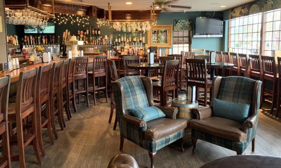 The inside dining area with lounge chairs and stools bordering the bar