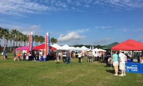 Vendor tents arranged for the Nocatee Classic Car Show at Station Field, under a blue sky