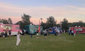 Four food trucks in different colors arranged on Station Field in Nocatee for Food Truck Friday