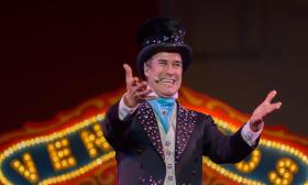 The ringmaster for Venardos Circus, smiling from the ring