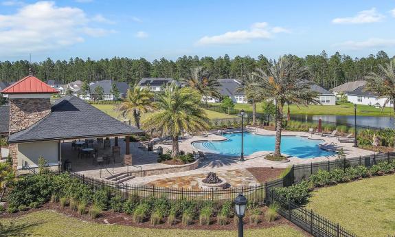 An outdoor swimming pool and lounging patio adjacent to the Oxford Estates' clubhouse