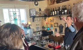 A bartender gestures as he describes wine to guests of a Spirits with Spirits Tour