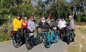This large family group smiles while taking in the view from their Island Life bikes at GTMNR