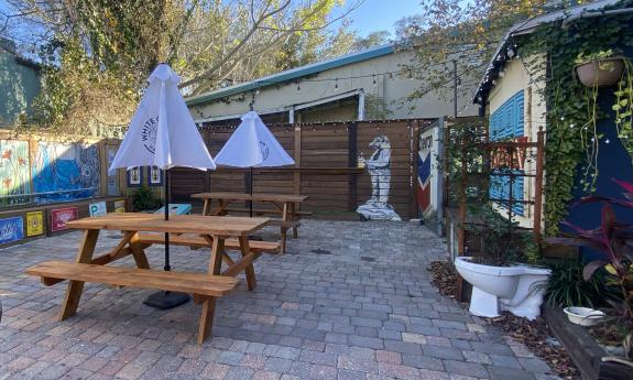 The back patio where there is additional seating and corn hole guests can participate in